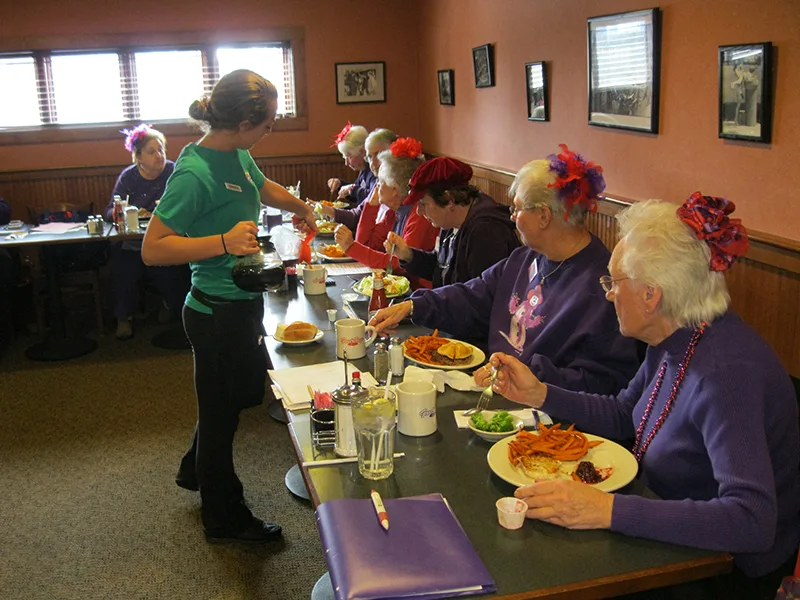A server checking in on a large group lunch